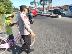Anggota Pos Pam Kanci Polresta Cirebon Bantu Warga Menyebrang Jalan